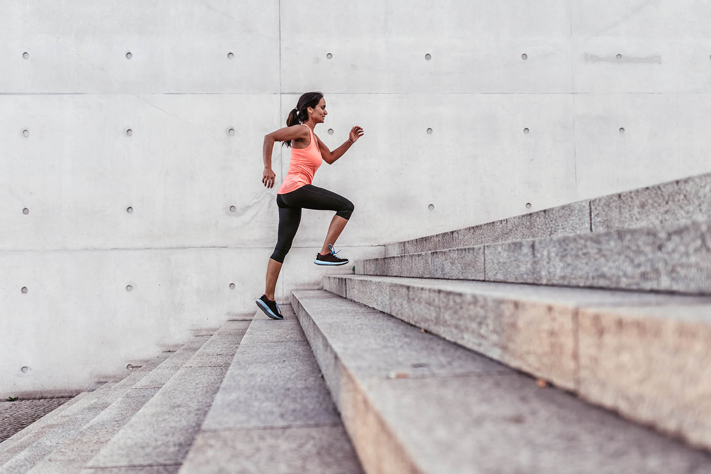 A woman running up concrete stairs