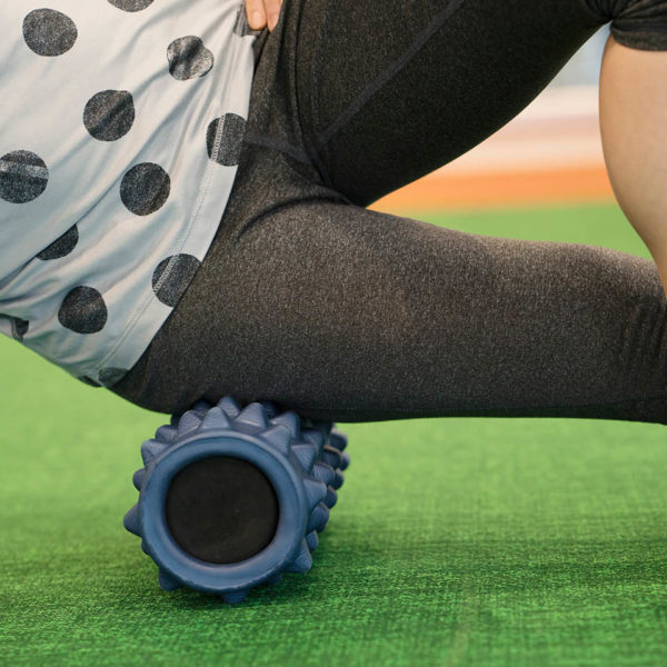 A person using a knobby foam roller