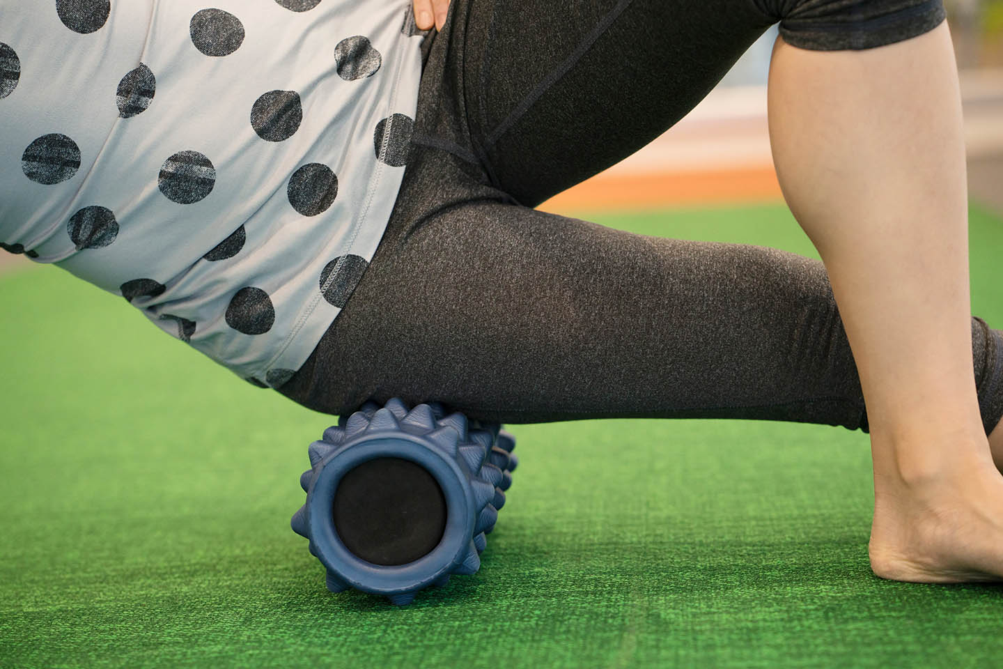 A person using a knobby foam roller