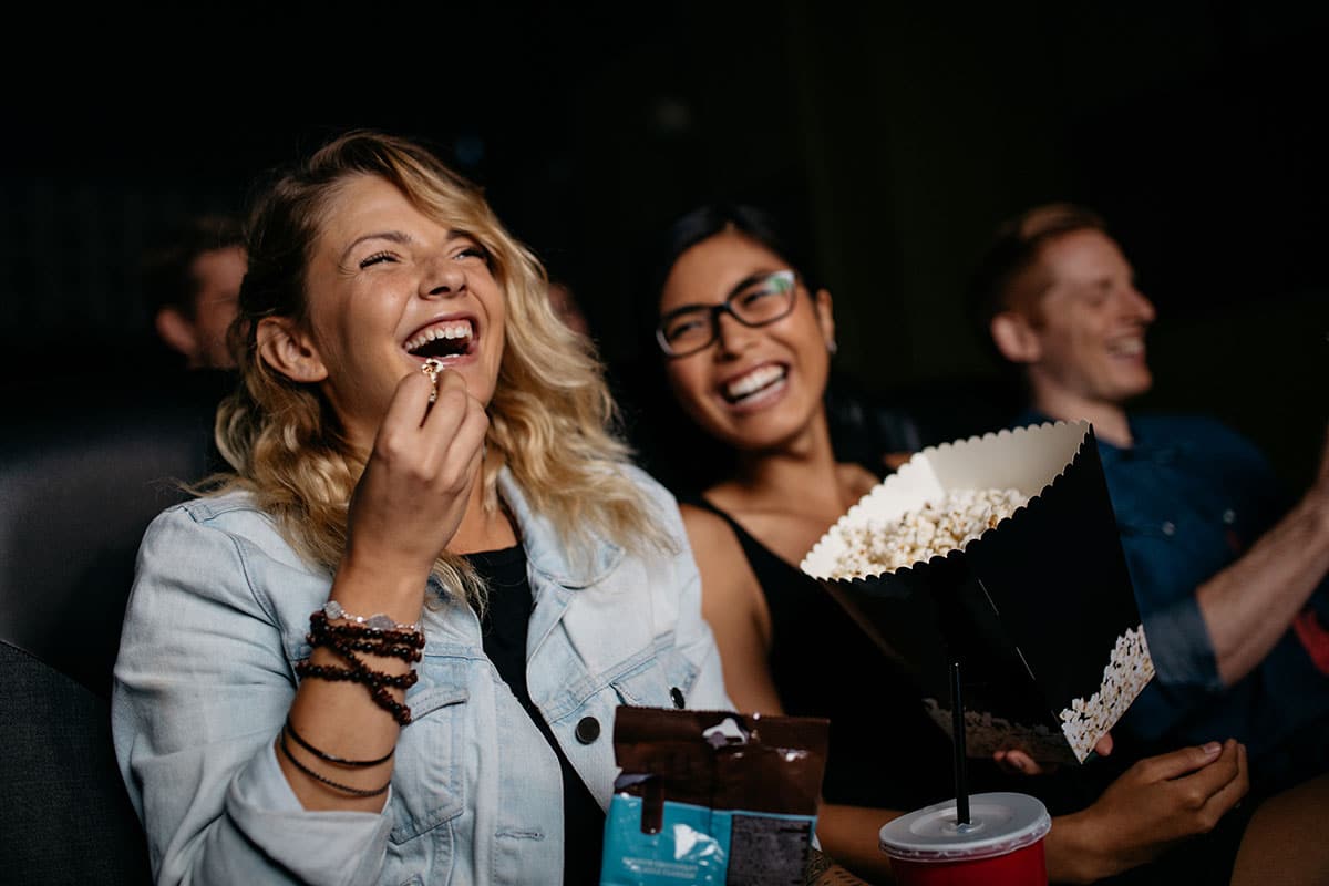 Women laughing in a movie theatre