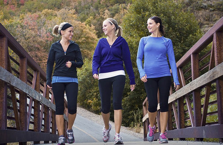 A group of three women walking outside.